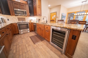 Enjoy cooking in this well-equipped kitchen with a central island, oven, and stainless steel appliances.