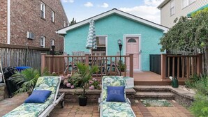 A two-story house with a turquoise exterior, a wooden deck, and a small front porch. - Margate Home w/ Large Outdoor Kitchen (Margate City)