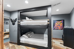 A bunk bed with a headboard, a small bedside table, and a wall-mounted shelf. - Night Owl 3 Bedroom Cabin by RedAwning (Gatlinburg)