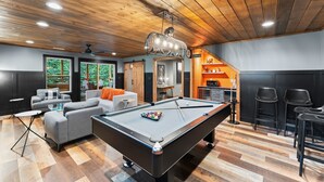 A modern living room with a pool table, grey sofas, and a ceiling fan. - Night Owl 3 Bedroom Cabin by RedAwning (Gatlinburg)