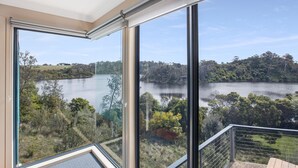 Ein Balkon mit Blick auf einen See und umliegende Bäume.