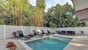 A swimming pool with lounge chairs and a white fence. - Sugaree -  2bedroom Private Pool Property in Holmes Beach (Holmes Beach)