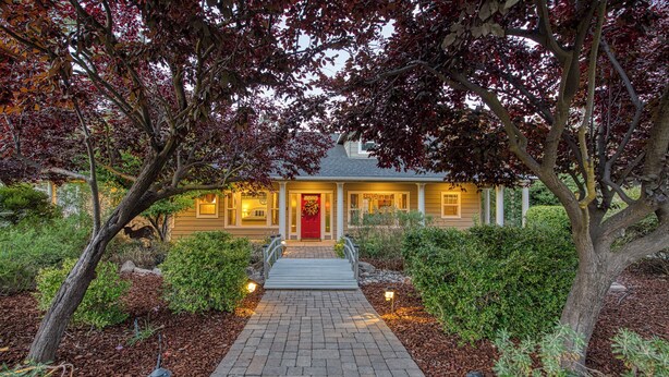 A house with a red door, a brick pathway, and a well-maintained garden.