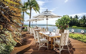 Enjoy al fresco dining on the deck surrounded by lush greenery and ocean views.