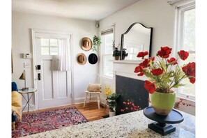 Enjoy a cozy stay in this stylish room featuring a fireplace, large window, and decorative touches.