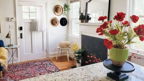 A room with a fireplace, a mirror, a door, and a window with red flowers. - The Haymount Eclectic by Haymount Homes (Fayetteville)