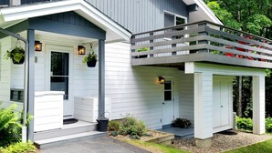 Een huis met twee verdiepingen, een veranda, een overdekte ingang en een klein terras.