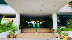 Una entrada de edificio moderno con una escalera que conduce a una puerta de cristal.