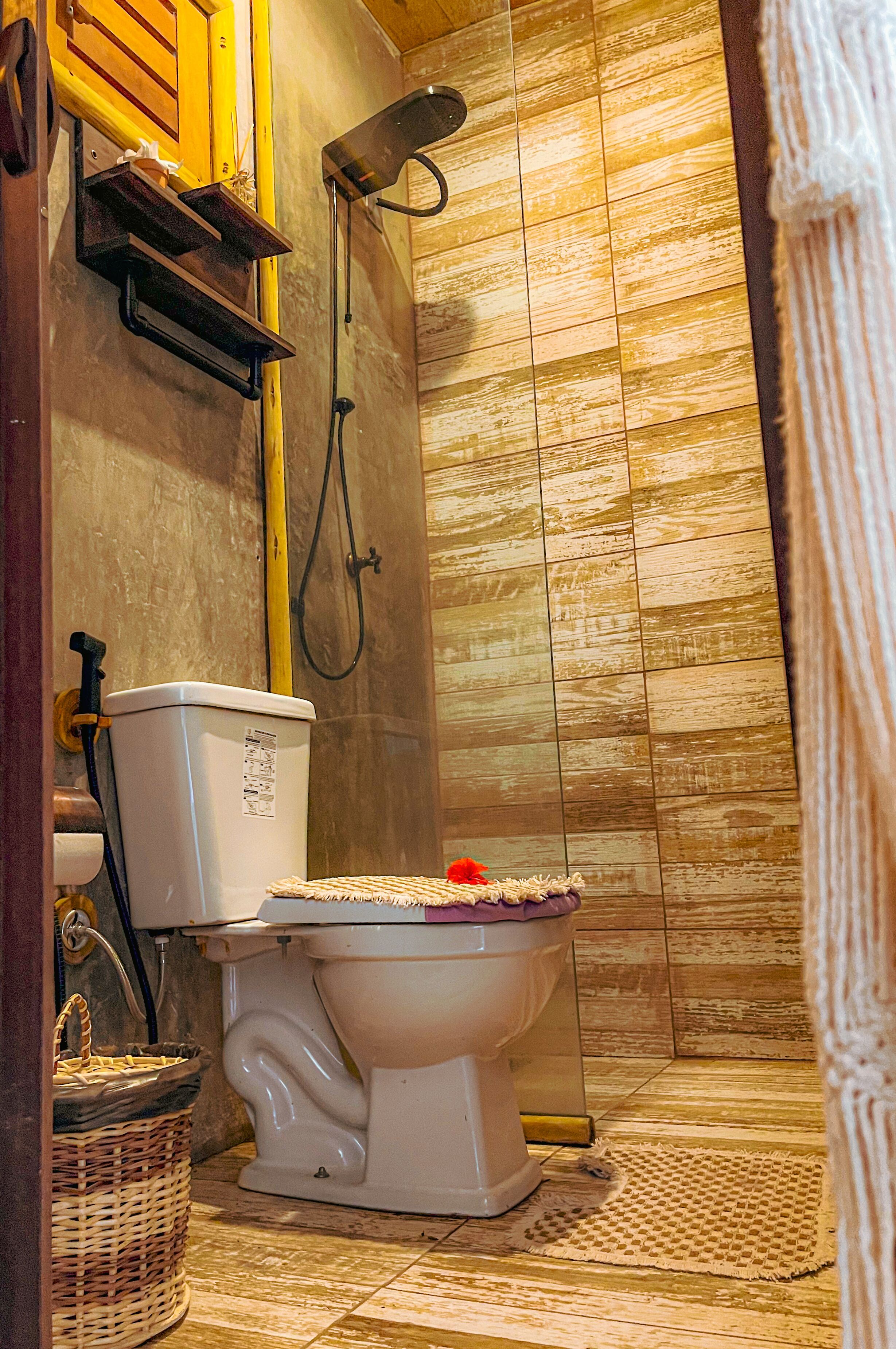 A bathroom with a toilet, a shower, and a tiled floor.