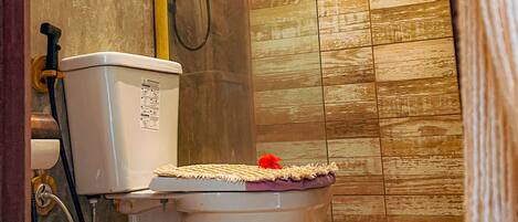 A bathroom with a toilet, a shower, and a tiled floor.