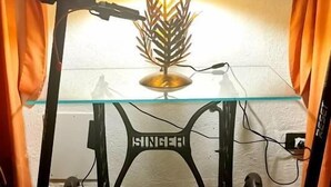A room with a glass-top table, a plant on the table, and two electric scooters on either side. - Hotel Tea Praia  (Praia a Mare)