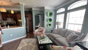 A spacious living room with a sofa, a coffee table, and a patterned rug. - Biloxi border, huge King size Condo (Gulfport)