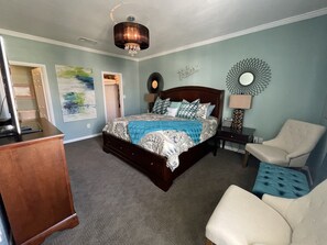 A bedroom with a bed, a chair, a dresser, and a desk. - Biloxi border, huge King size Condo (Gulfport)