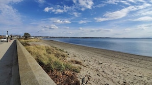 En strand med en gångbana av betong och gräsytor.