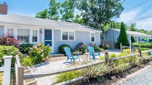 A motel with a simple exterior, a gravel driveway, and two blue chairs in front. - 1/2 Mile to Nantucket Sound Beaches! (Dennis Port)