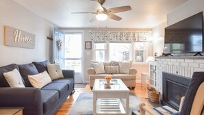 A living room with a sofa, a coffee table, a fireplace, and a television. - 1/2 Mile to Nantucket Sound Beaches! (Dennis Port)