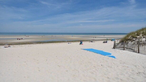 A beach with a sandy shore, a wooden fence, and a clear sky. - 1/2 Mile to Nantucket Sound Beaches! (Dennis Port)