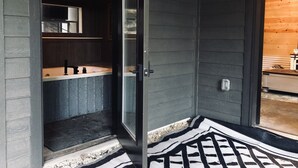 Une salle de bain moderne dotée d’une grande baignoire, d’une cabine de douche en verre et d’un intérieur en bois.