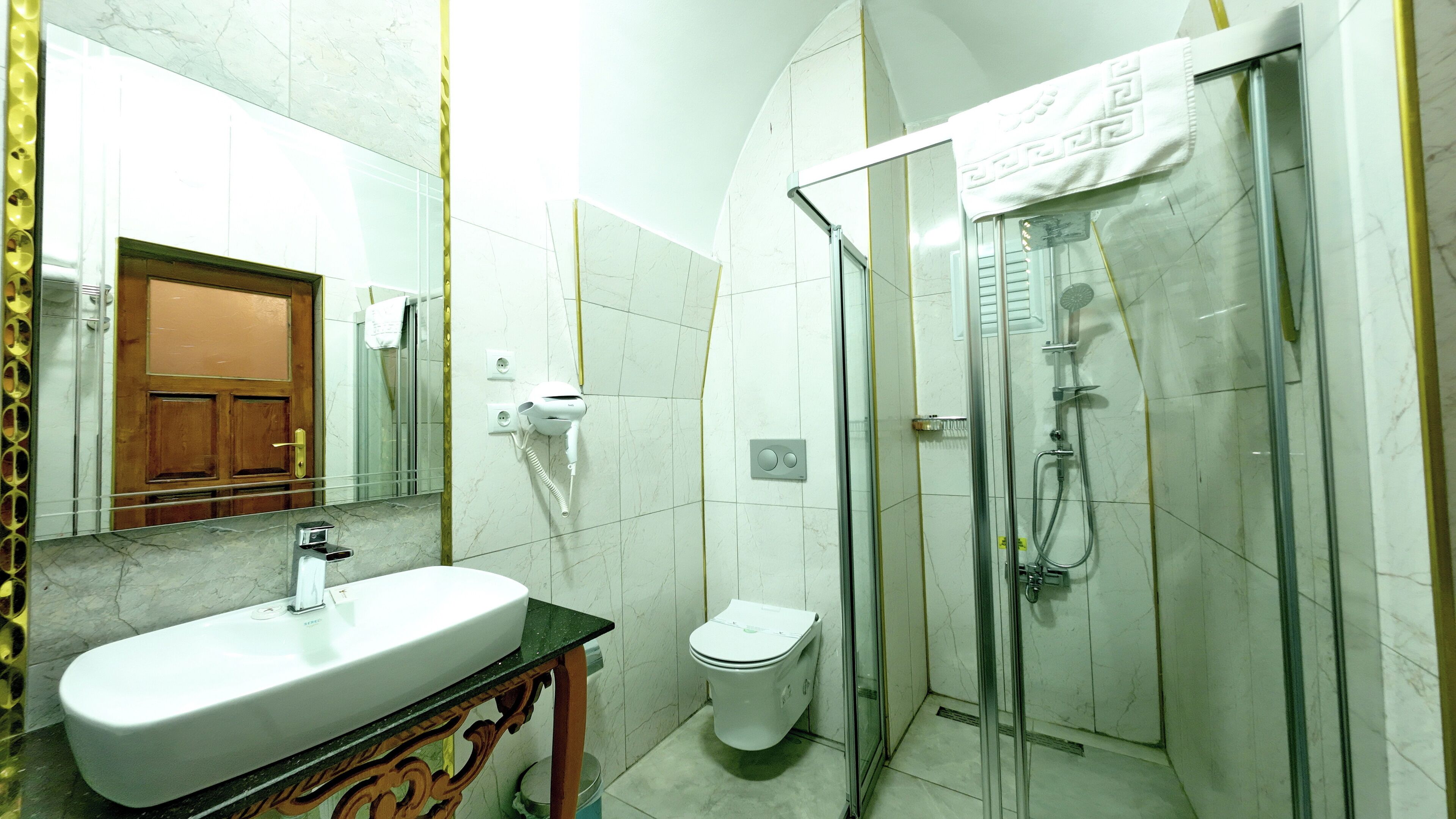 A bathroom with a sink, toilet, and glass-enclosed shower.