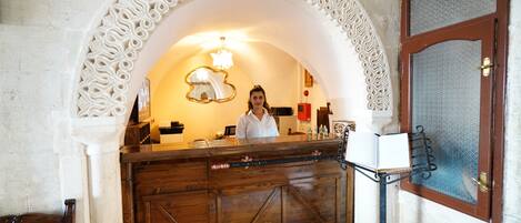 Un mostrador de recepción con encimera de madera y un arco decorativo.