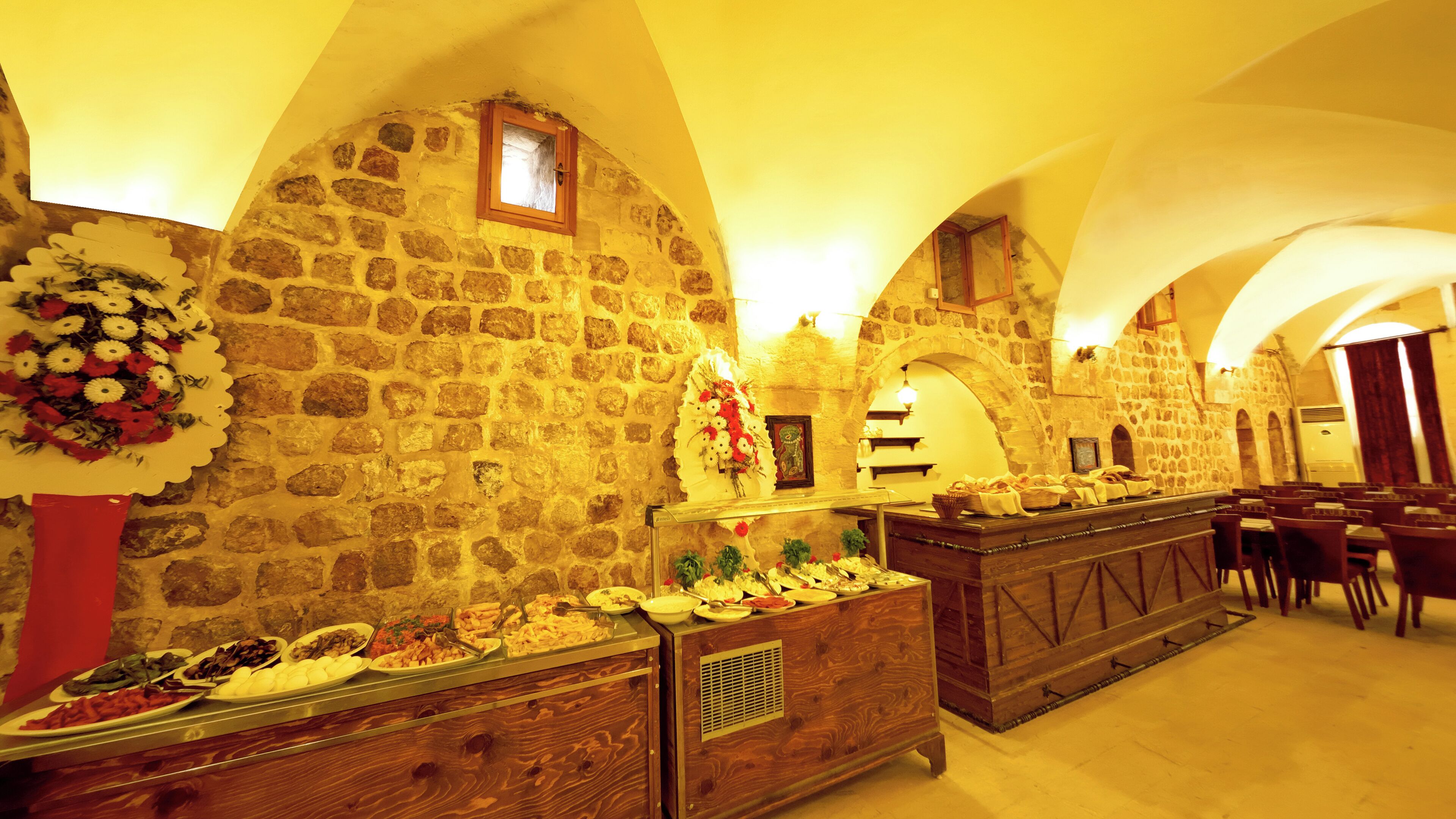 Un espace buffet avec des murs en pierre et des comptoirs en bois.