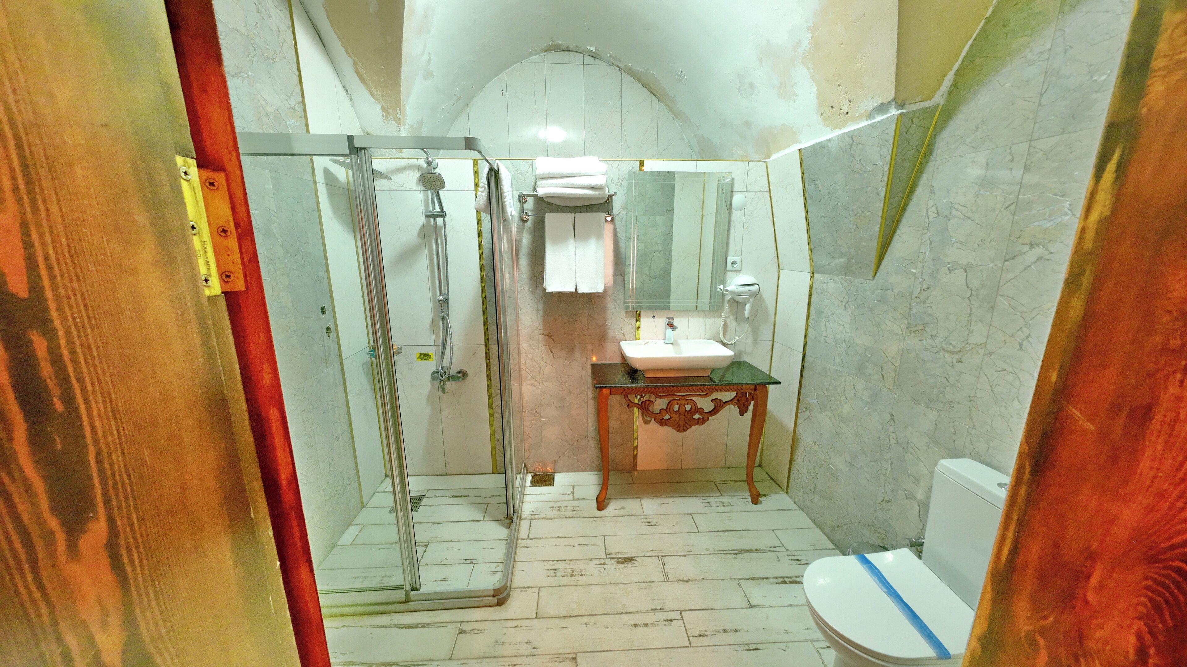 A bathroom with a shower, sink, and toilet.