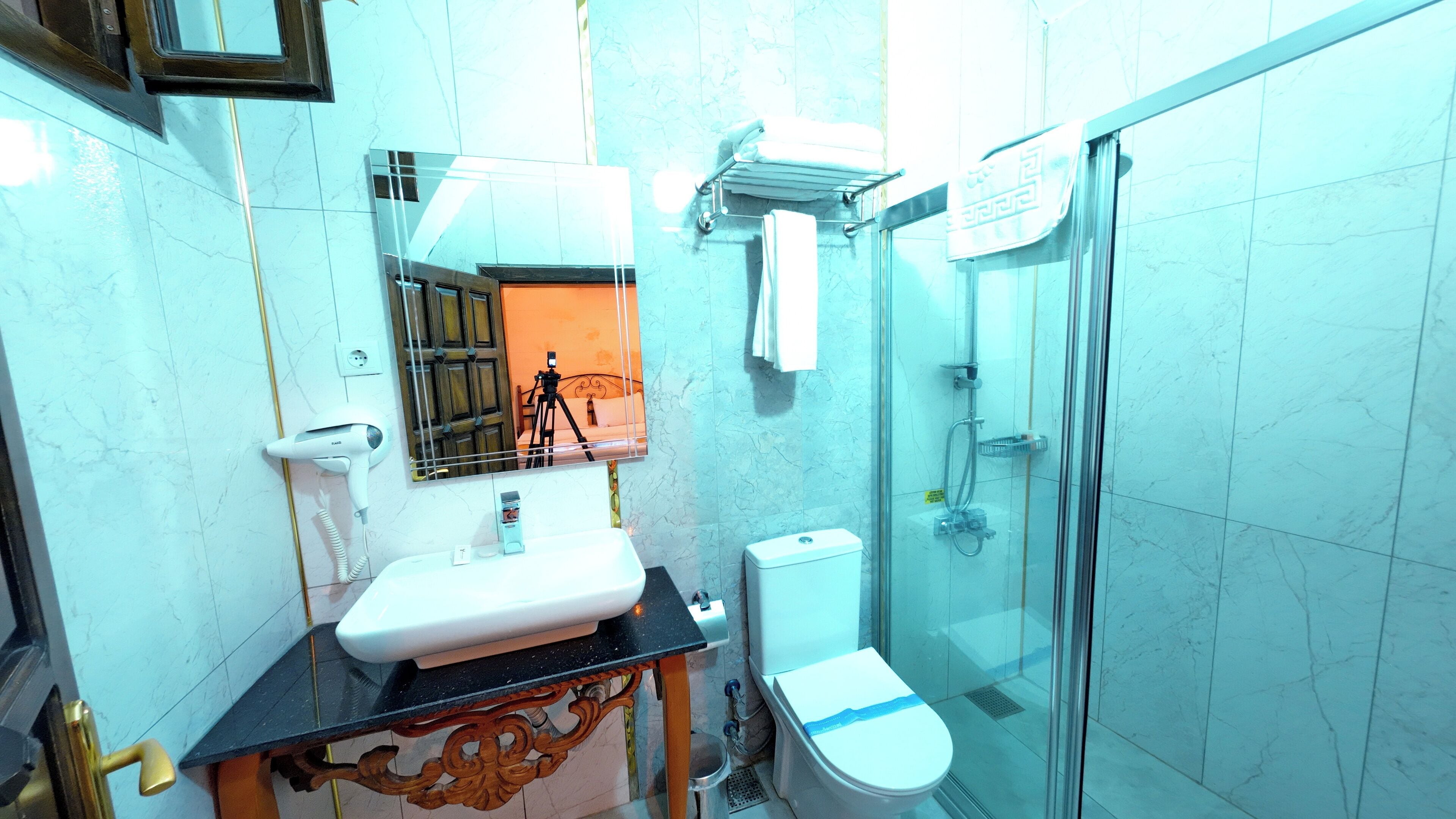 A bathroom with a sink, toilet, and glass-enclosed shower.