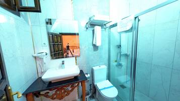 A bathroom with a sink, toilet, and glass-enclosed shower.