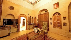 A spacious living room with a television, a sofa, a coffee table with flowers, and wooden furniture. - Ulubey Konagi (Mardin)