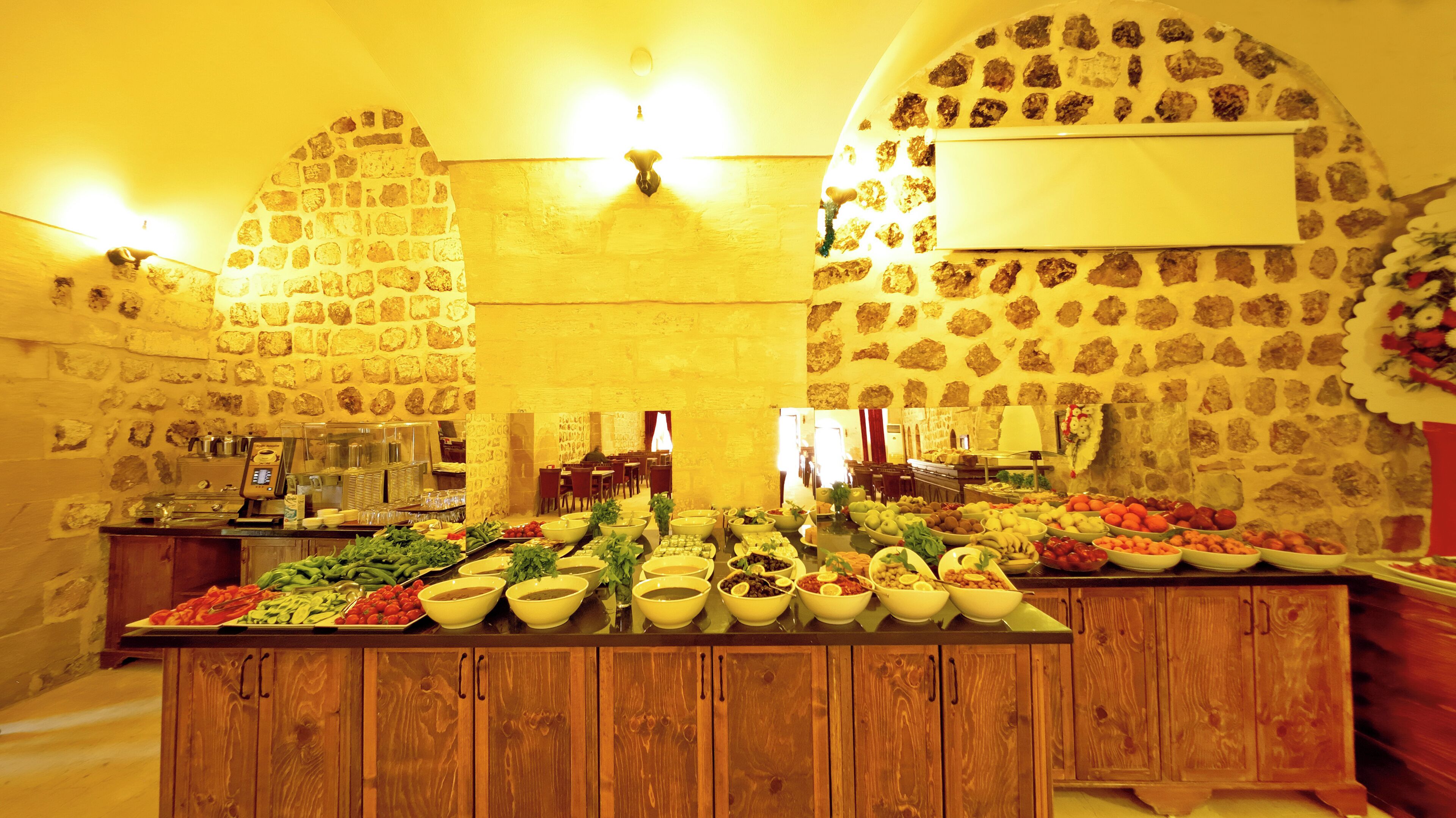 A buffet with various food items and a stone wall with a clock.