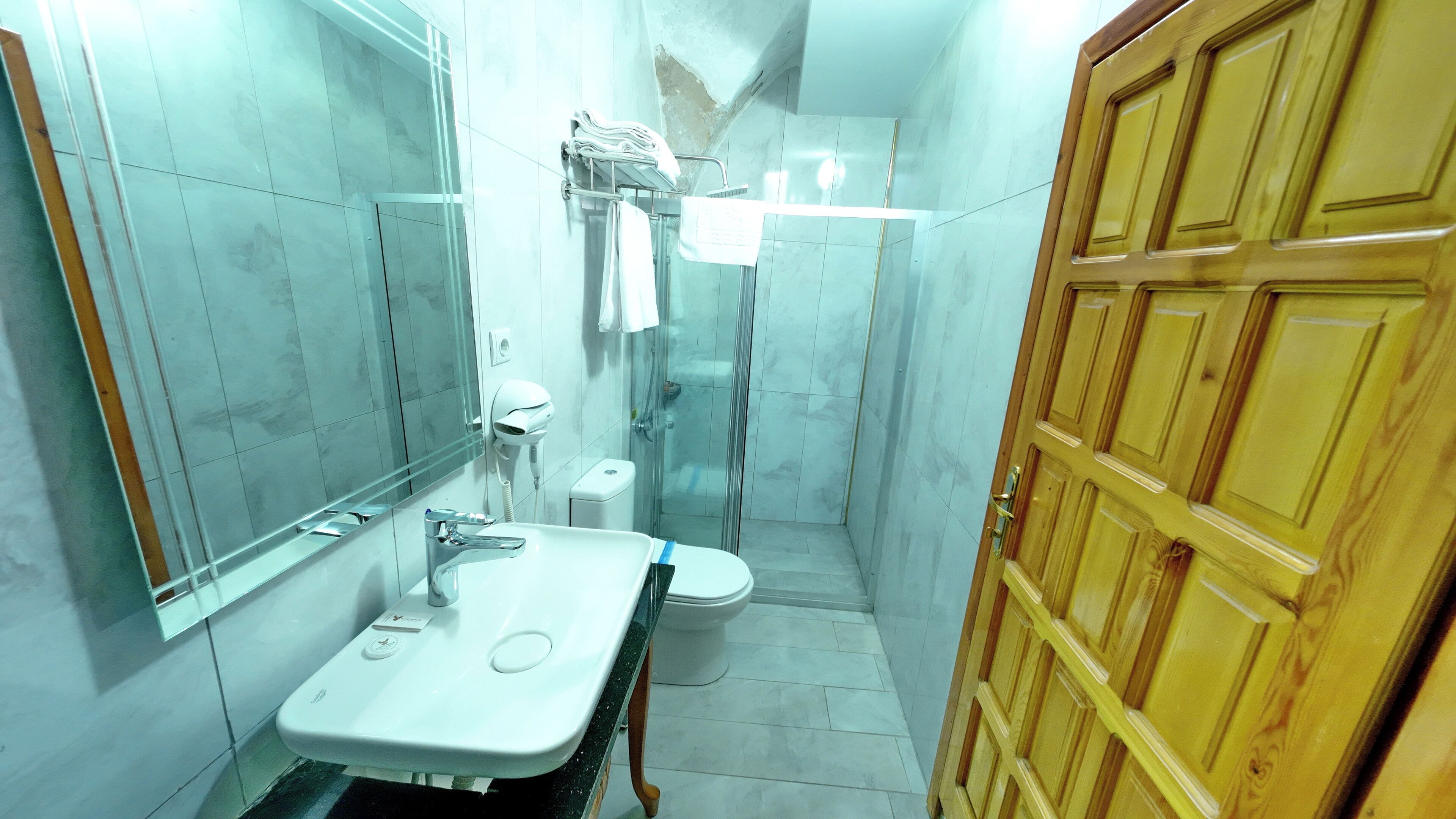 A bathroom with a sink, toilet, and shower.