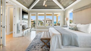 A spacious bedroom with a large bed, a ceiling fan, and a view of the ocean through large windows. - 7BR Gulf Views, Large Private Pool/Spa, Private Beach/Gated Community, Sleeps 20 (Destin)