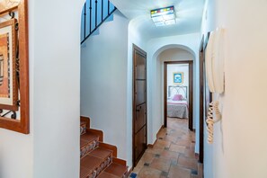 Una escalera conduce a un dormitorio con una cama y una mesita de noche.
