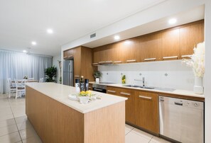Una cocina moderna con armarios de madera, una isla central y electrodomésticos integrados.