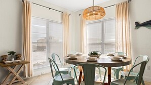 Een eethoek met een ronde tafel, vier stoelen en een hanglamp.