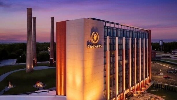 En stor, moderne bygning med et tydeligt "Caesars" skilt, der har en høj struktur med mange vinduer og en velbelyst facade.