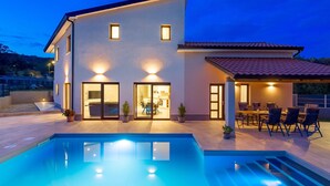 A modern house with a swimming pool, a patio with outdoor furniture, and a well-lit interior. - Gorgeous home in Rijeka (Rijeka)