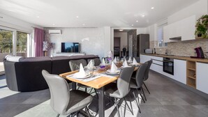 A modern living room with a dining area, a sofa, and a TV. - Gorgeous home in Rijeka (Rijeka)