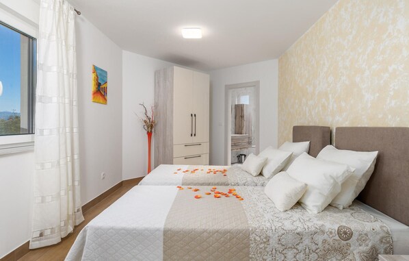 Habitación de hotel con dos camas, un baño y vistas al exterior.