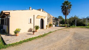 A single-story building with a stone facade, a large arched doorway, and a small balcony. - Luxurious home in Sineu (Sineu)