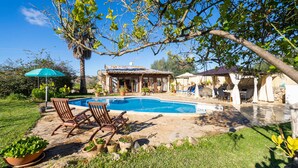 A pool area with lounge chairs, a covered patio, and a stone deck. - Luxurious home in Sineu (Sineu)