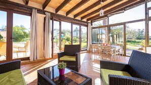 A spacious patio area with wicker furniture, large sliding glass doors, and a view of the garden. - Luxurious home in Sineu (Sineu)