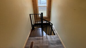 A narrow stairway with a wooden handrail and a window at the top. - Unique Cavalier Log Cabin nestled in the forest, 15 mins to Hocking Hills (Logan)
