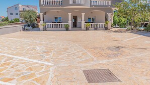 A two-story building with a stone-paved courtyard, a central entrance, and balconies with railings. - 1 bedroom lovely apartment in Brodarica (Brodarica)