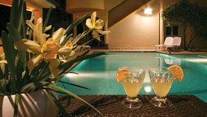 A poolside setting with a table featuring two drinks garnished with orange slices, surrounded by yellow flowers. - 1 bedroom lovely apartment in Brodarica (Brodarica)