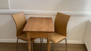 A corner room with a wooden table and two chairs, white walls, and a radiator. - Center, modern renovated old town apartment, Torster #3 (Hameln)