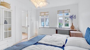Ein Schlafzimmer mit einem Bett, einem Schreibtisch und einem Fenster.