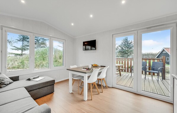 Enjoy a serene view from the large window, with a comfortable sofa and dining area.