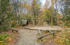 Simple shelter surrounded by natural elements in a forested area.