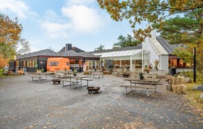 Relax in the serene outdoor seating area surrounded by trees and a charming café.